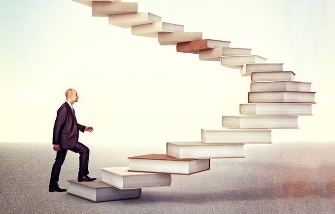 書籍の階段を上るビジネスマン