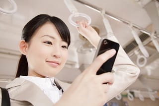 通勤中にスマホを見る女性